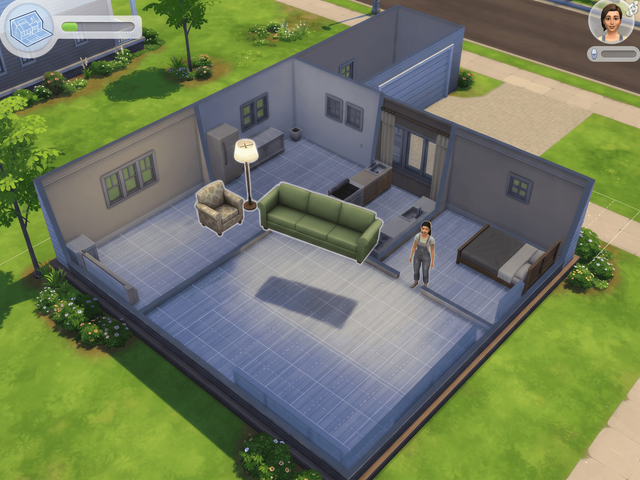 A roofless house seen from above in build mode, with a floor grid and a sofa and armchair floating above the rooms